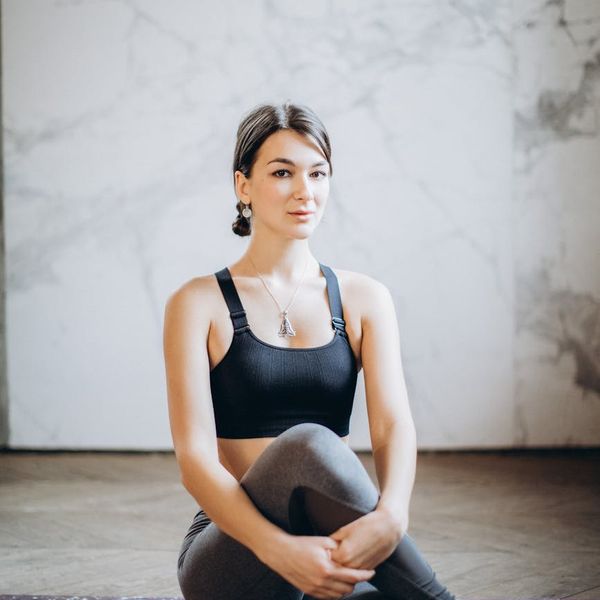 Person stretching on a yoga mat in a bright, airy room.